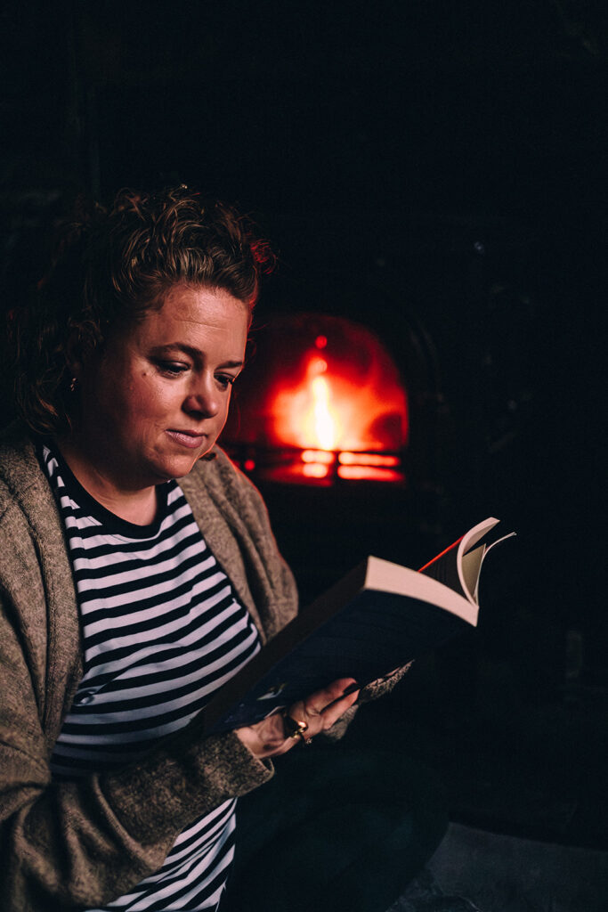 Jo Hooper, reading by fire. Running business course and freedom coaching